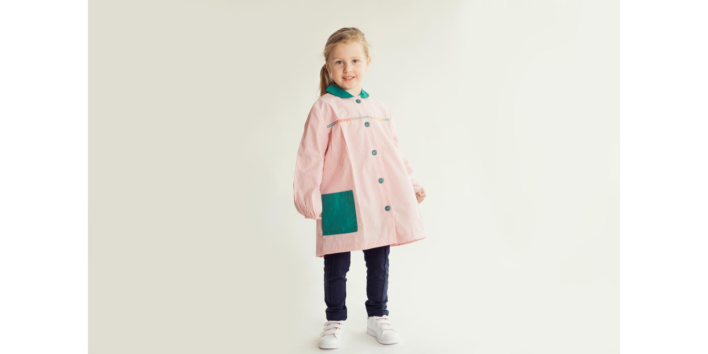 Modèle portant une blouse scolaire pour école à rayures roses