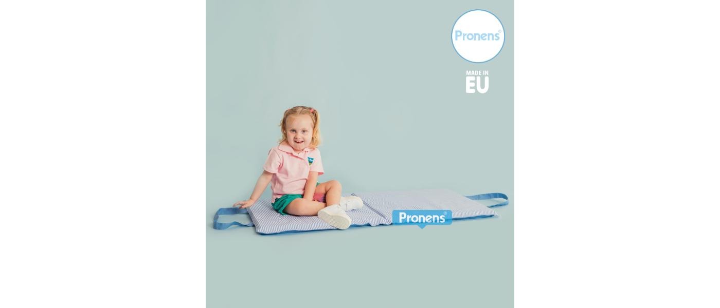 Niña de 3 años sentada sobre márfega colchoneta escolar